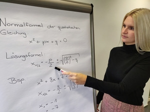 Ausbildungsleiterin Friederike Looschen erklärt ihren Auszubildenden die Lösungsformel für quadratische Bestimmungsgleichungen - © Friederike Looschen